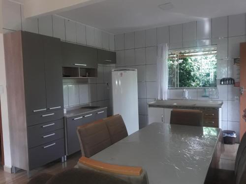 a kitchen with a table and a white refrigerator at Recanto do Sossego in Alto Caparao
