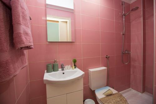 a pink bathroom with a sink and a toilet at Sea Side Rooms in Rhodes Town