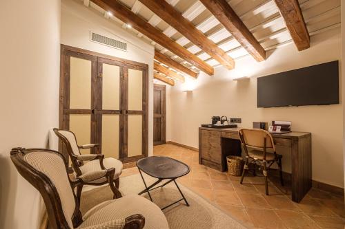 a room with chairs and a desk and a television at Hotel Mas La Boella in La Canonja