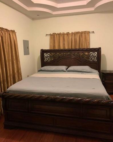 a bedroom with a large bed with a wooden frame at Comfortable home in San Fernando in San Fernando