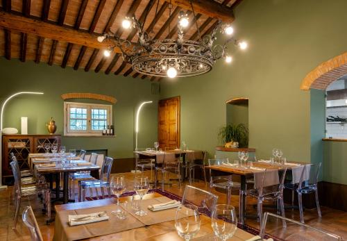 una sala da pranzo con tavoli e sedie e un lampadario di Agriturismo San Rocco a Pistoia
