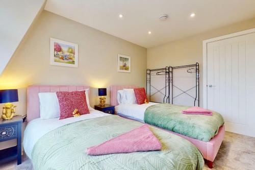 two beds in a bedroom with pink and green at Chatham Serviced Apartments by Hosty Lets in Chatham
