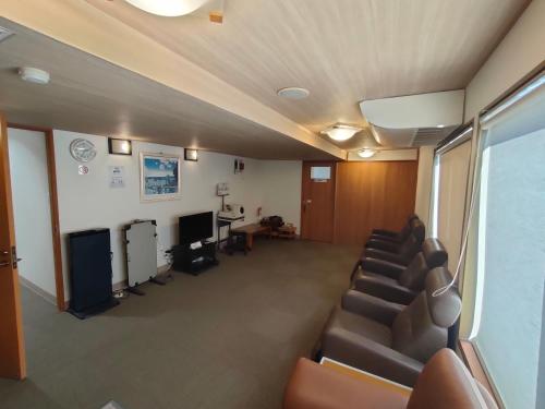 a waiting room with leather chairs and a television at Hotel Edoya in Tokyo