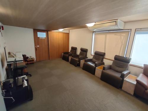 a waiting room with leather chairs and a desk at Hotel Edoya in Tokyo