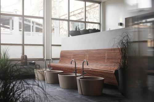 a row of sinks in a room with a bench at Varbergs Kusthotell in Varberg