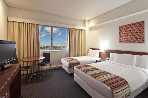Postel nebo postele na pokoji v ubytování Macleay Hotel