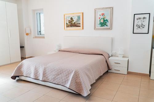 a bedroom with a bed and a white wall at Villa Eletti in Matera