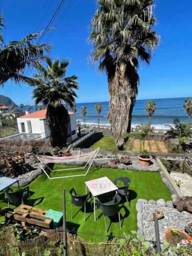 un patio trasero con mesa y sillas y la playa en Baia Seixal Oceanfront, en Seixal