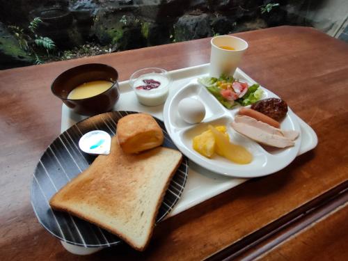 a tray of breakfast food with a plate of bread and toast at Hotel Edoya in Tokyo
