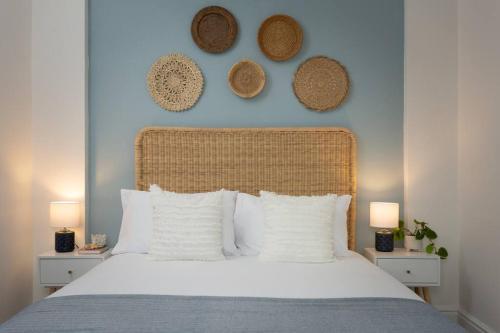 ein Schlafzimmer mit einem weißen Bett mit drei Hüten an der Wand in der Unterkunft High Tide - Filey apartment close to beach in Filey
