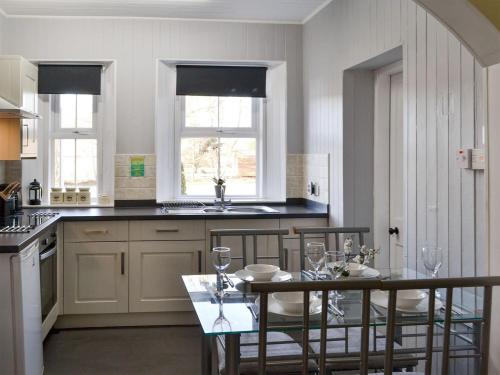 a kitchen with a table with chairs and a sink at The Retreat in Belladrum