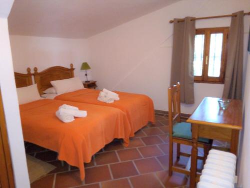 1 dormitorio con 2 camas y toallas. en Finca San Ambrosio - Apartments in grüner Oase mit Terrasse, Pool, Heizung, WiFi, en Vejer de la Frontera