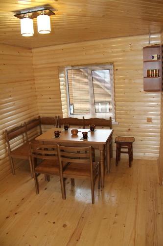 a dining room with a table and chairs and a window at Kray Dorogy in Yaremche
