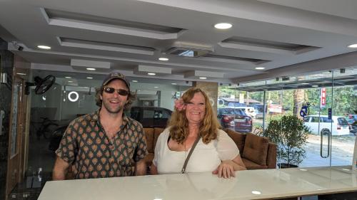 a man and a woman standing at a counter at Dreams Paradise Airport Residency in Nedumbassery