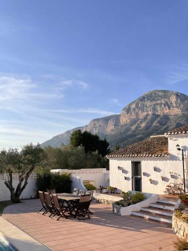 a patio with a table and chairs with mountains in the background at Casa Venezuela in Jávea