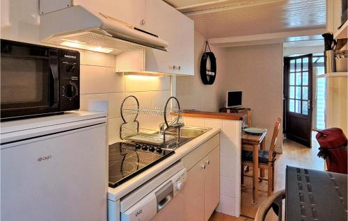 une cuisine avec une cuisinière et un micro-ondes dans l'établissement Beautiful Apartment In Grandcamp-Maisy, à Grandcamp-Maisy