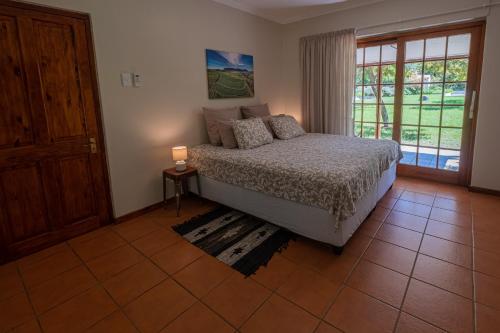 a bedroom with a bed and a large window at Eden Studios in Riebeek-Kasteel