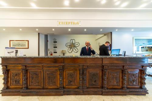 Zwei Männer standen an einer Bar in einem Laden. in der Unterkunft Hotel Sakura in Torre del Greco