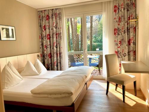a hotel room with a bed and a window at Garni Villa Siesta Park in Losone