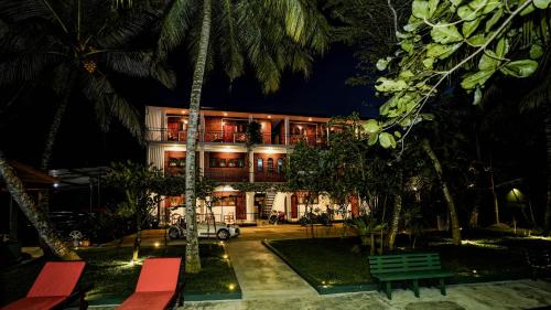 a building with palm trees in front of it at River Inn - Fort in Matara