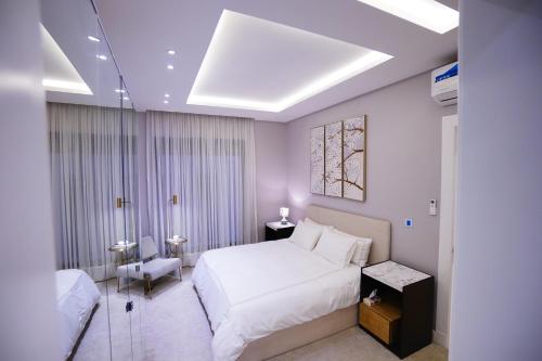 Spacious and Modern Apartment for Rent in Ergah, Riyadh في الرياض: غرفة نوم بسرير ابيض كبير وكرسي