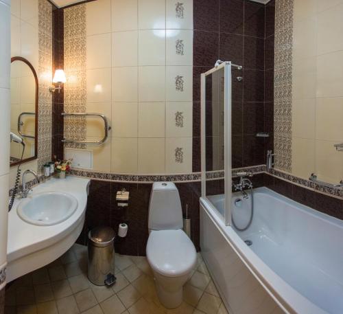 e bagno con servizi igienici, vasca e lavandino. di Garni Hotel a Minsk