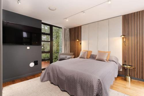 een slaapkamer met een groot bed en een flatscreen-tv bij Luxury Water Tower I Roof Bar I Cinema in Cardiff