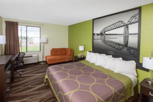 a hotel room with a large bed and a desk at Super 8 by Wyndham Southaven in Southaven