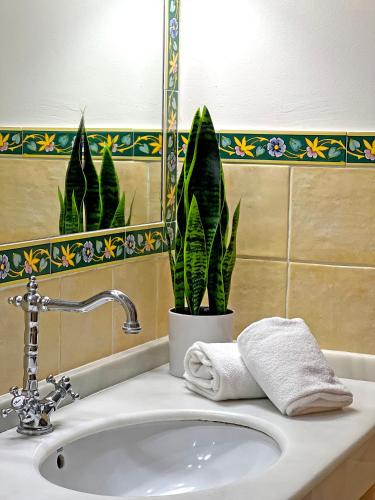 a bathroom sink with a towel and a potted plant at Itaca Sevilla by Soho Boutique in Seville