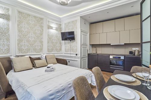 Cet appartement comprend une chambre avec un lit blanc et une cuisine. dans l'établissement Apartment Louvre Museum by Studio prestige, à Paris