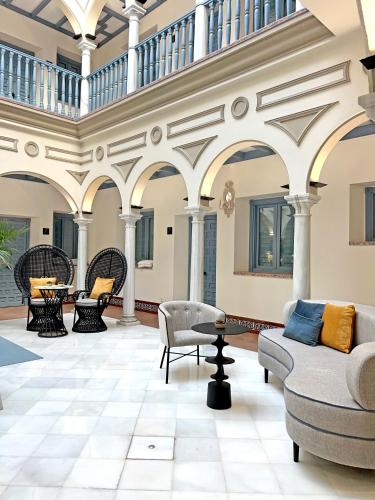 a large living room with chairs and tables at Itaca Sevilla by Soho Boutique in Seville