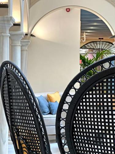two black chairs sitting on a porch with a couch at Itaca Sevilla by Soho Boutique in Seville