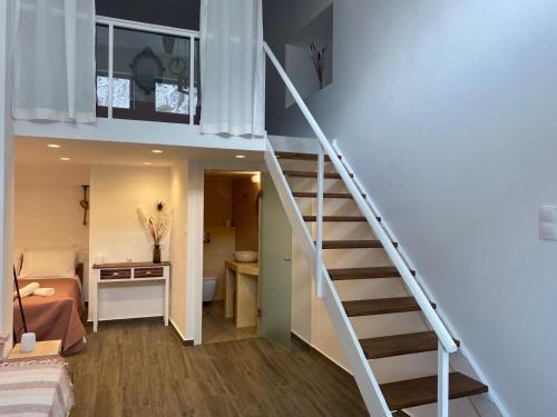 a staircase leading up to a bedroom in a tiny house at Galanos Katoikies in Órmos Aiyialís