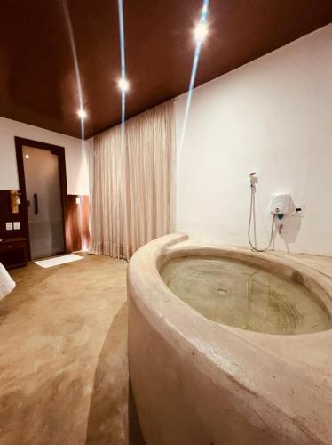 uma grande casa de banho com uma grande banheira num quarto em Refúgio da Rita em Fernando de Noronha