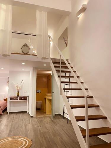 a white staircase in a living room with a desk at Galanos Katoikies in Órmos Aiyialís