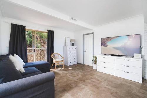 a living room with a couch and a flat screen tv at Oceanview Manor by "Peppy Beach Retreats" - Two Houses in One with Panoramic Views in Capel