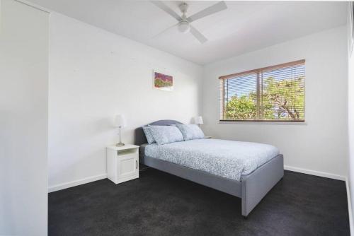 a white bedroom with a bed and a window at Oceanview Manor by "Peppy Beach Retreats" - Two Houses in One with Panoramic Views in Capel