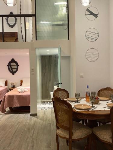 a dining room with a table and chairs and a bed at Galanos Katoikies in Órmos Aiyialís