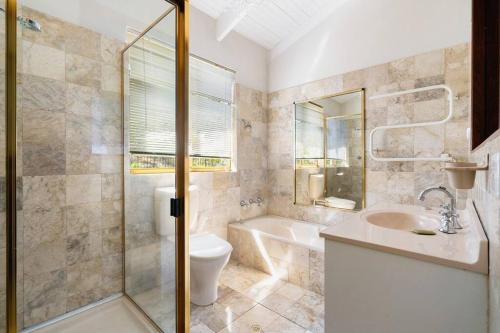 a bathroom with a toilet and a sink and a shower at Oceanview Manor by "Peppy Beach Retreats" - Two Houses in One with Panoramic Views in Capel