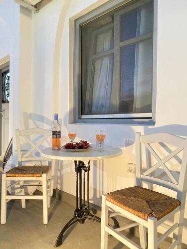 a table with two chairs and a table with drinks on it at Galanos Katoikies in Órmos Aiyialís