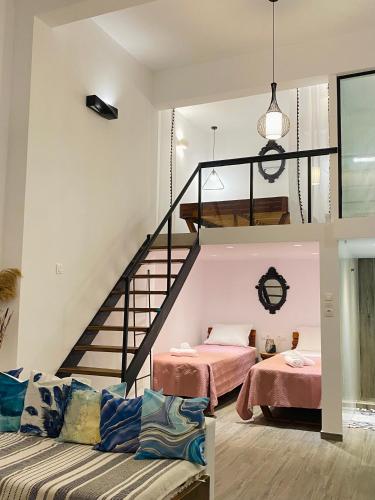 a living room with two beds and a staircase at Galanos Katoikies in Órmos Aiyialís