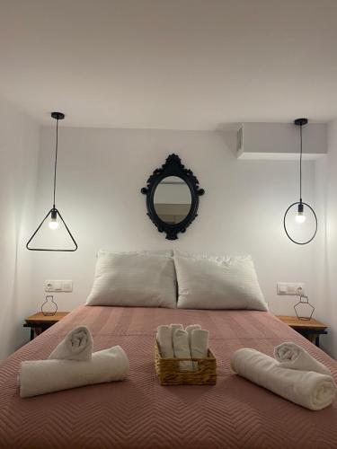 a bedroom with two towels on a bed with a mirror at Galanos Katoikies in Órmos Aiyialís