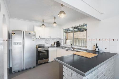 a kitchen with stainless steel appliances and a black counter top at Oceanview Manor by "Peppy Beach Retreats" - Two Houses in One with Panoramic Views in Capel