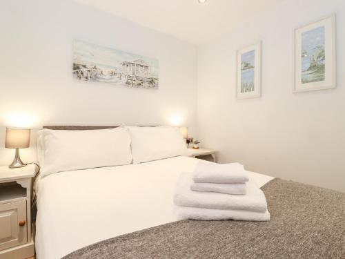 a bedroom with a white bed with towels on it at Canny Cottage in Morpeth