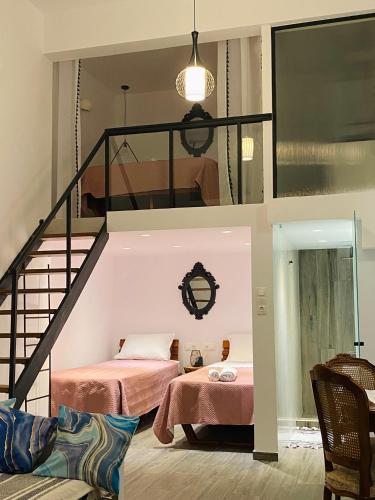 two beds in a room with a loft at Galanos Katoikies in Órmos Aiyialís