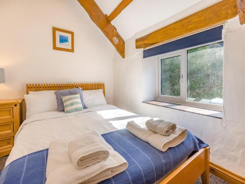 a bedroom with a bed with towels on it at Jarvies Cottage in Boscastle