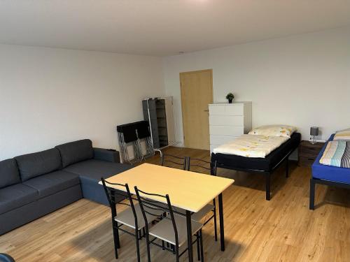 uma sala de estar com um sofá, uma mesa e uma cama em Beautiful, large and great apartment with balcony in top location em Karlsruhe