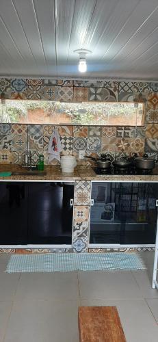 een keuken met een fornuis en een aanrechtblad bij Pousada Fazenda e Pesqueiro Chalé da serra in Conceição da Ibitipoca