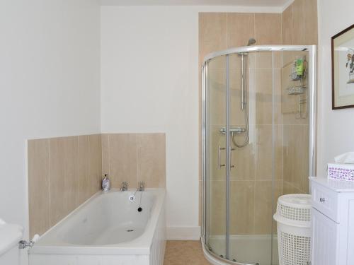 een badkamer met een bad en een glazen douche bij Prospecthill House in Whitehouse