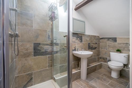 a bathroom with a shower and a toilet and a sink at The Penthouse At Quayside in York